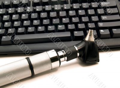 Otoscope next to computer keyboard