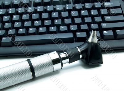 Otoscope next to  keyboard