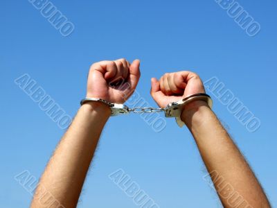 The hands of the men chained in handcuffs