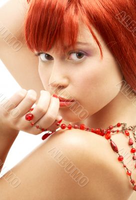 redhead with red beads looking over shoulder