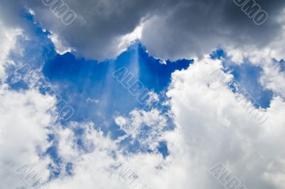 cloudscape with rays of sunlight behind big clouds