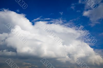 big white clouds approaching in a blue sky