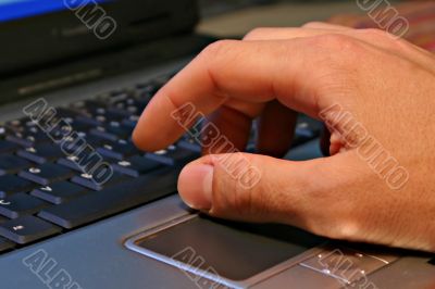 Hand on notebook keyboard