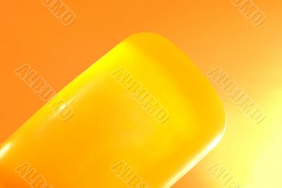 Piece of yellow soap on an orange background