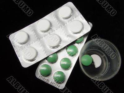 isolated green and white pills on black background isolated green and white pills on black background