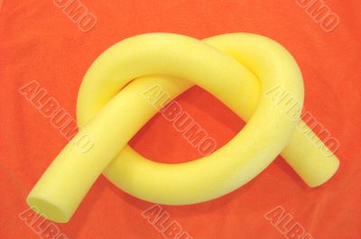 Yellow aqua noodle on orange
