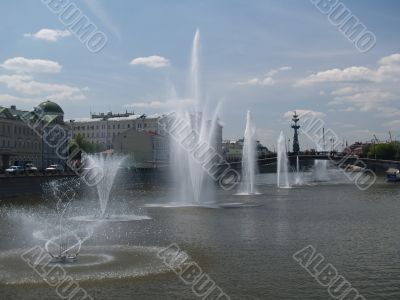 Fountains on the river in summer day