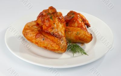 Fried chicken wings in tomato sauce.