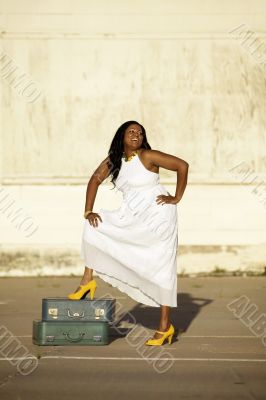 African American woman with suitcases laughs