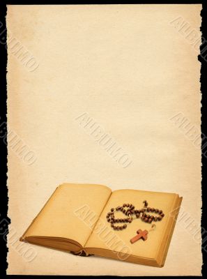 torn out old sheet of paper with book and rosary
