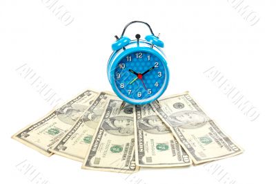 Alarm clock over a fan of money