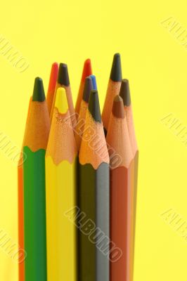 bunch of colorful pencils on yellow background