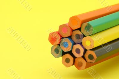 bunch of colorful pencils on yellow background