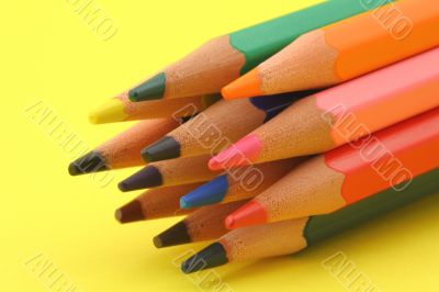 bunch of colorful pencils on yellow background