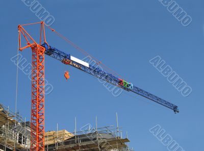 Orange and blue crane on construction site Orange and blue crane on construction site
