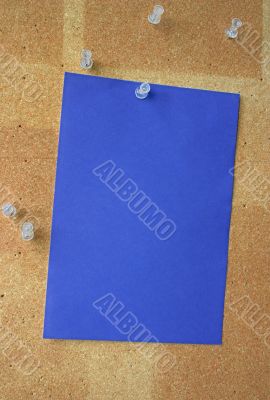 blue paper sheet pinned to corkboard