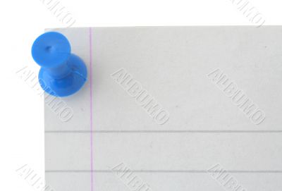 the edge of a lined sheet of paper with a pin