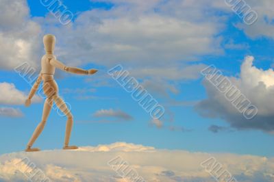 woden figure walking on clouds