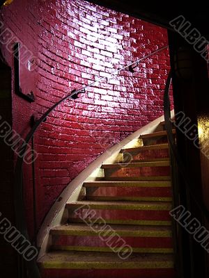 Spiral staircase and stark red brick wall