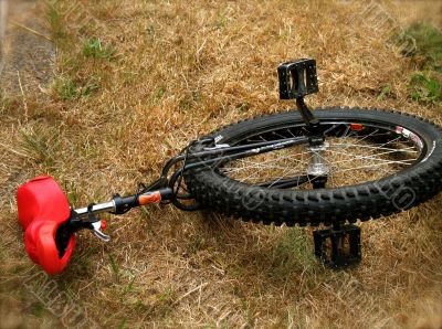 A unicycle with red seat at rest