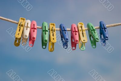 Clothespins on a cord on a background of the sky