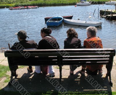 four friends relaxing at the waters edge