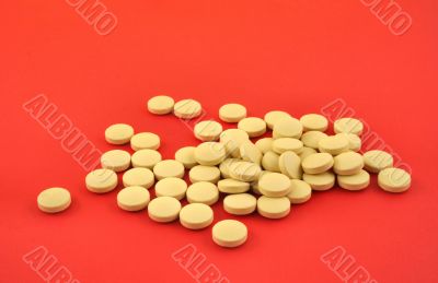 handful of yellow tablets on red