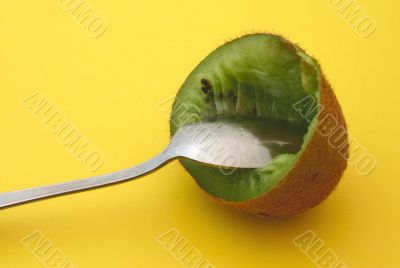 hollow kiwi with spoon on yellow
