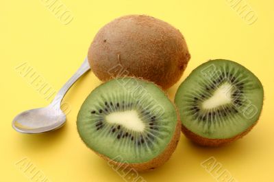 kiwis with spoon on yellow