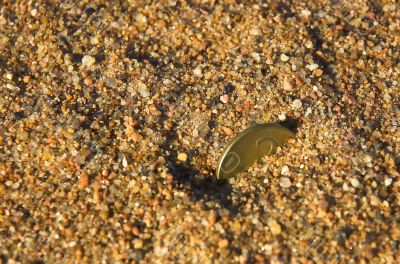 Copper coin in sand close up