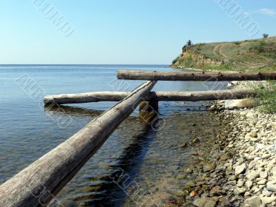 Logs and stones on seacoast