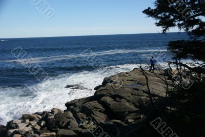 Visitor watching the tide from rocky perch