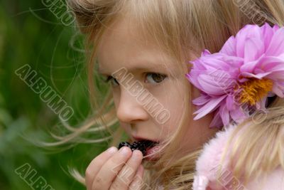 little girl eats blackberry