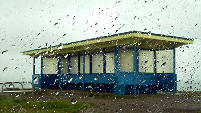 beach shelter seen through rain covered glass