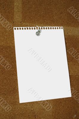 blank paper sheet thumbtacked to cork board