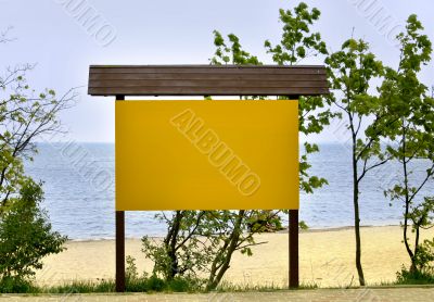 empty noticeboard, sea in background