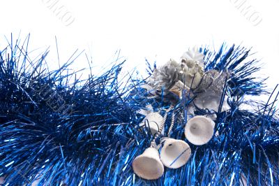 white bells lie on blue new-year tinsel