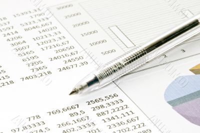 pen showing diagram on financial report/magazine