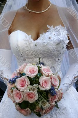 Bride torso with bouquet in white wedding dress