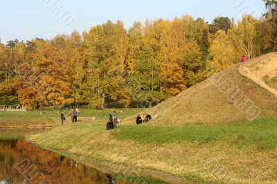 Picturesque autumn landscape of river, hill and bright trees and bushes