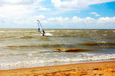 Windsurfing. Seashore. Hot sand. Dark blue sky.