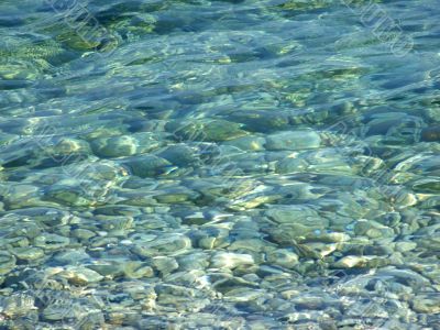 pebbles under a blue surface of sea water