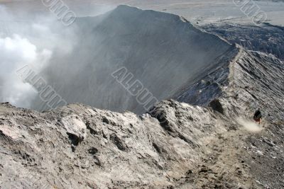 Lonely man walking on the edge of volcano