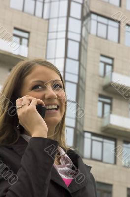 The young woman speaks by phone in the street