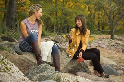 Two girls having a rest in autumn park