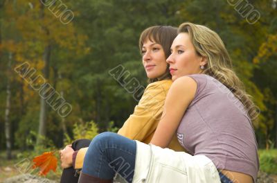 Two girls having a rest in autumn park