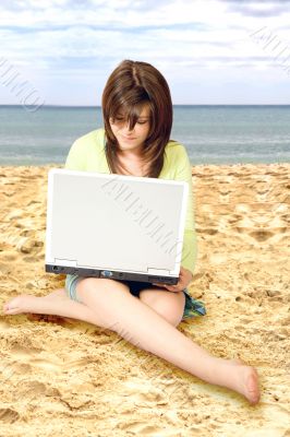 casual girl using a laptop on the beach casual girl using a laptop on the beach