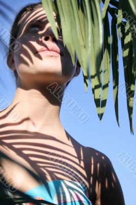 Beautiful woman in bikini with leafy shade