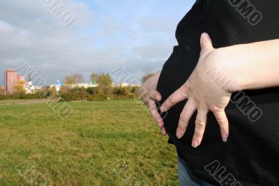 Stomach of pregnant woman with her hands