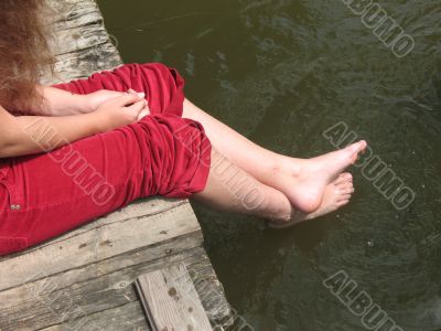A young girl sits on the bridge A young girl sits on the bridge
